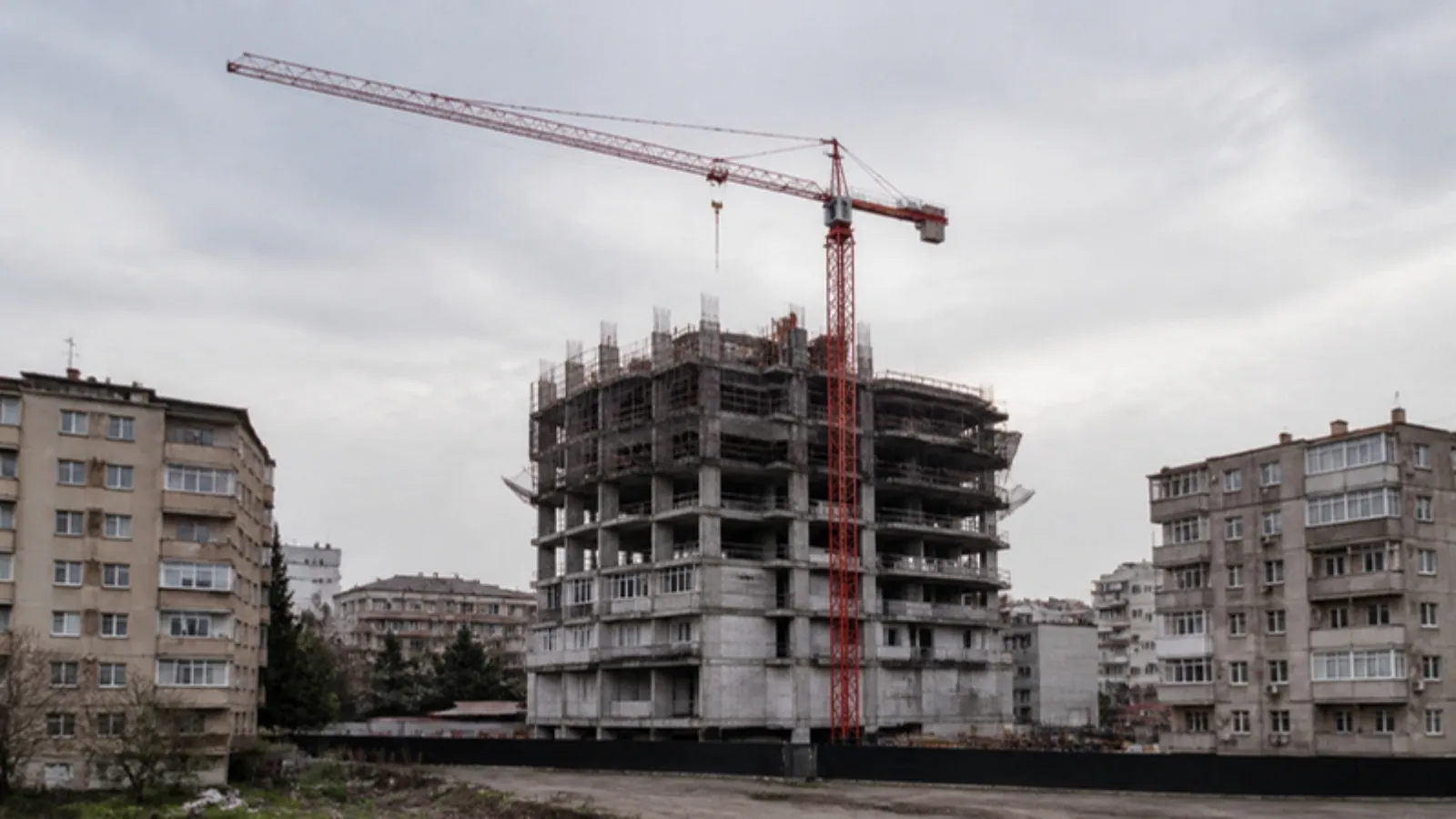 Eski apartmanların arasında yükselen yeni konut inşaatı ve kırmızı kule vinç