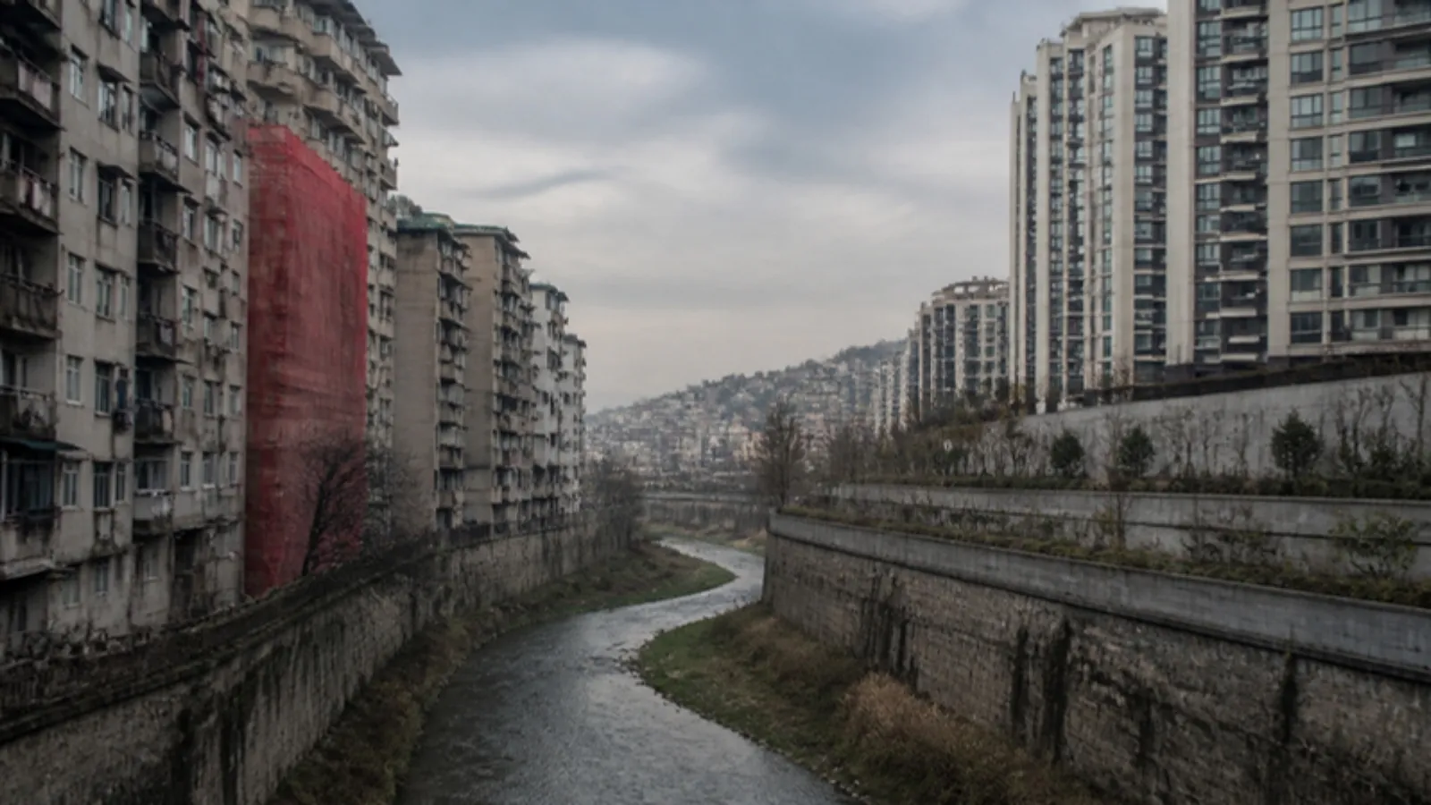 Dere kanalının iki yakasında eski apartmanlar ve yeni konut kuleleri