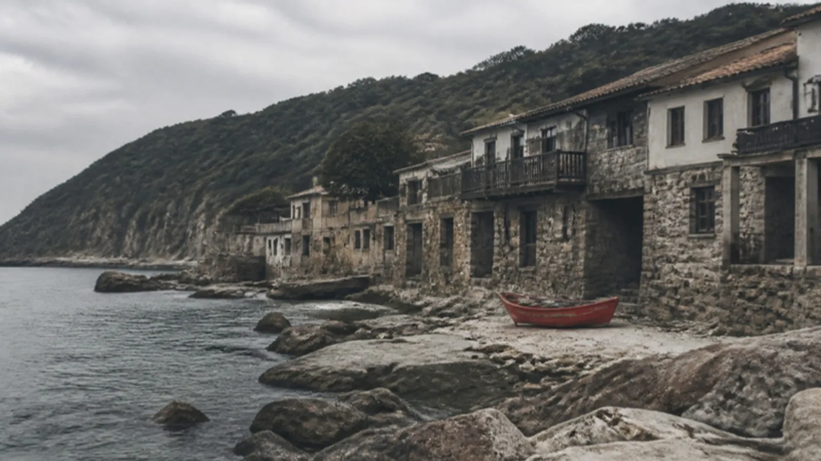 Karadeniz kıyısında eski az katlı taş evler ve balıkçı teknesi
